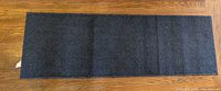 Full view of blue diamond-textured runner rug on hardwood floor