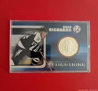 Front of sealed coin card showing action photo and silver-tone coin