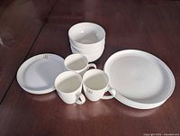 Group view of stacked plates, bowls and mugs