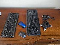 Two Logitech keyboards, two mice, Dynex hub and receiver on table