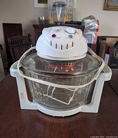 Front view of Oyama convection oven showing control head, glass bowl, base, power cord