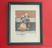 Framed signed photo showing mat, frame, image, signature and inscriptions