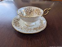 Teacup on saucer showing gold iris pattern and trim