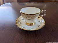 Teacup on saucer showing pattern and gold trim