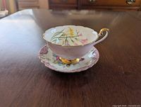 Shelley teacup on saucer showing freesia motif, gold accents