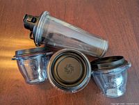 Full view of blending cup with lid and three bowls showing lids and logos