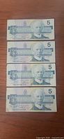 Fronts of four Canadian $5 notes showing Sir Wilfrid Laurier