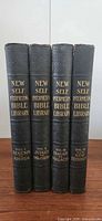 Spine view of all four volumes showing titles and volume numbers