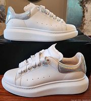 Lateral side view both shoes on box showing heel detail and sole condition