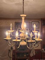 Full view of chandelier hanging with all eight bulbs lit