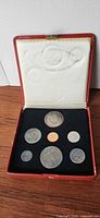 Open case showing all coins and medallion in insert
