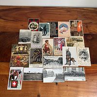 All 20 antique postcards arranged on wood surface