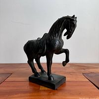 Full left side view of horse sculpture on wooden surface