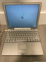 Laptop open, powered on showing Apple logo during boot