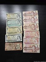 Full lot overview showing arrangement of Canadian $1 and $2 notes and Bahamas $5 note