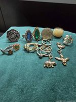 Full group of rings and charms on green fabric