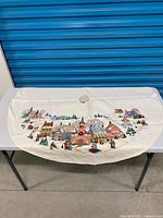 Full view of entire tree skirt laid flat showing stitched village scene