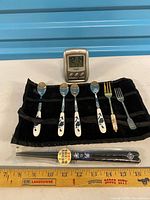 Overview showing clock, five utensils, chopsticks and velvet roll