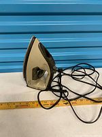 Profile view of iron showing body, handle, cord