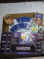 Overall lot showing playmat, cards, tin and booklets