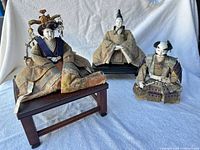 Overview of three seated Hina dolls on fabric backdrop