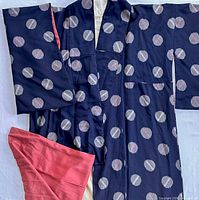 Front view of navy silk kimono showing dot motif and coral lining