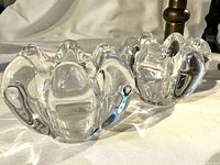 Two clear crystal tulip-shaped votive holders side by side