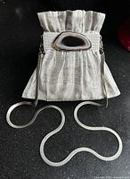 Front view of stainless steel mesh evening bag with agate accent and chain strap