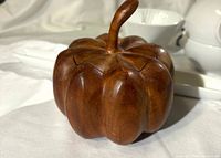 Front view of carved pumpkin box with lid on and stem visible