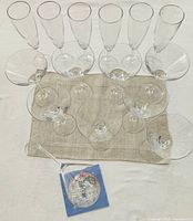 All 18 clear glass pieces arranged on cloth: martini glasses front, champagne flutes rear