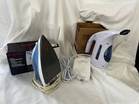 Hilife garment steamer, Impress iron, both boxes, cords, manual and measuring cup visible
