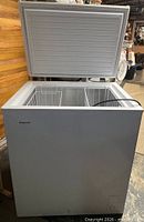 Chest freezer lid open showing wire baskets