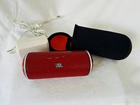 Front view of red JBL Flip speaker, charger, neoprene case