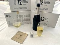 Stacked Martha Stewart Essentials boxes for white wine and stemless champagne flute glasses with example wine glass and flute in foreground
