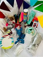 overview of party supplies including plates, utensils, balloons, banner