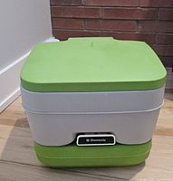 Front view of Dometic green/grey portable toilet