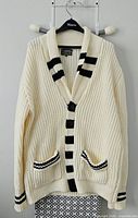 Full view of cardigan sweater on hanger showing overall style