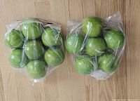 Two plastic bags containing thirteen artificial green apples