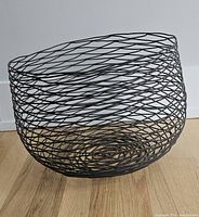 full view of black wire basket on wood floor
