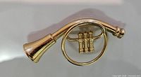 Miniature brass French horn profile view