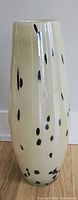 Full view of tall cream vase with black spots