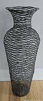 Full view of black wire vase standing upright