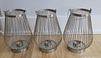 Three silver wire cage lanterns front view