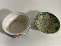 Overview of both ceramic pieces: cachepot left, oval dish right