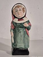 Full view of glazed ceramic figurine standing upright