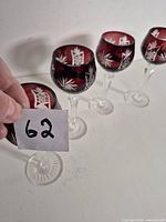 Four ruby red cut crystal goblets numbered 62