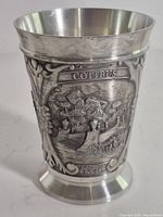 Overall view of pewter goblet showing relief landscape panel