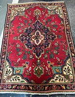 Full view of Persian rug showing design, borders and colors