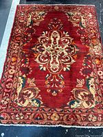 Full view of red Persian rug showing entire field and borders