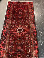 Full view of red Persian runner rug showing pattern and borders
